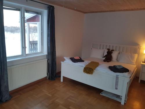 a bedroom with a white bed with a teddy bear on it at The Friendly Moose in Övertorneå