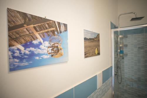 a bathroom with three pictures on the wall at Hello World in Agrigento