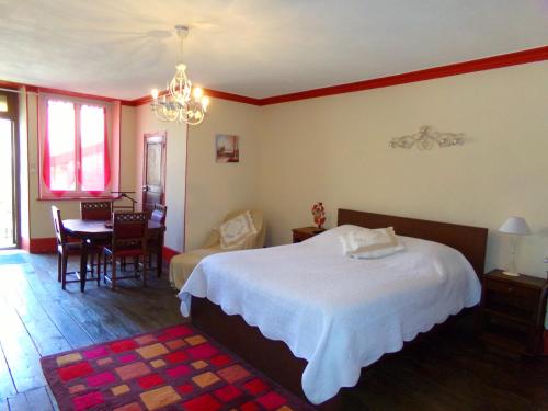 a bedroom with a bed and a table and chairs at Chez Monique in Doulaincourt