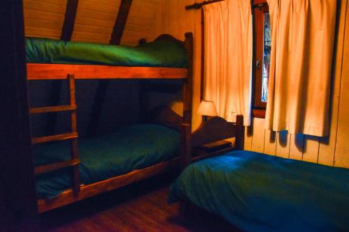 Uma ou mais camas em beliche em um quarto em Cabañas Villa Pañil
