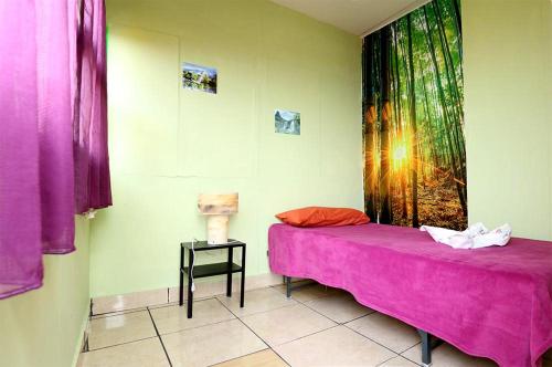 a bedroom with a pink bed and a side table at B&B Amigos de la Naturaleza in Las Manchas