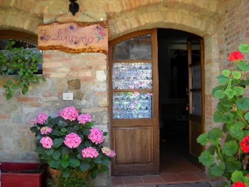 a door to a store with flowers in front of it at Poggio Al Vento in Castiglione dʼOrcia