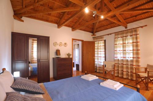 Schlafzimmer mit blauem Bett und Holzdecken in der Unterkunft Alikias Country House in Panormos Skopelos