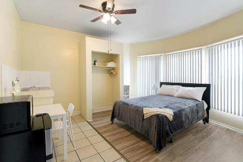 a bedroom with a bed and a desk and a ceiling fan at Pads on Pasadena Ave in Los Angeles