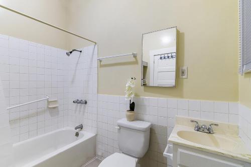 a bathroom with a toilet and a tub and a sink at Pads on Pasadena Ave in Los Angeles