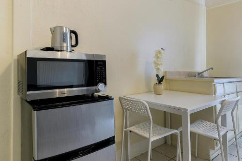 a kitchen with a microwave and a table with chairs at Pads on Pasadena Ave in Los Angeles