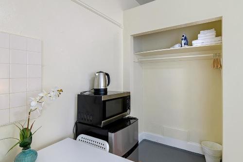 a kitchen with a microwave sitting on top of a table at Pads on Pasadena Ave in Los Angeles