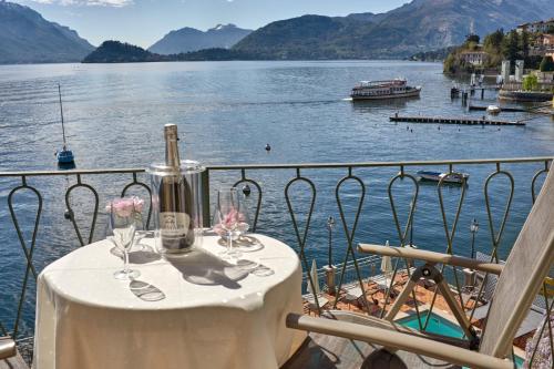 a table on a balcony with a view of a lake at Hotel Bellavista in Menaggio