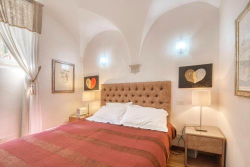 una camera da letto con un grande letto con una coperta rossa di Virgo Apartment a Roma