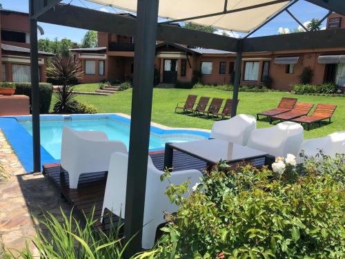 a patio with white chairs and a swimming pool at Cabañas San Lorenzo in San Lorenzo