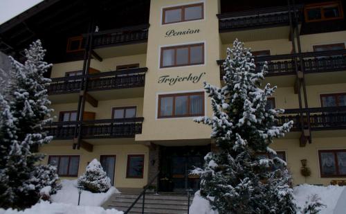 a large building with snow covered trees in front of it at Pension Trojerhof in Heiligenblut