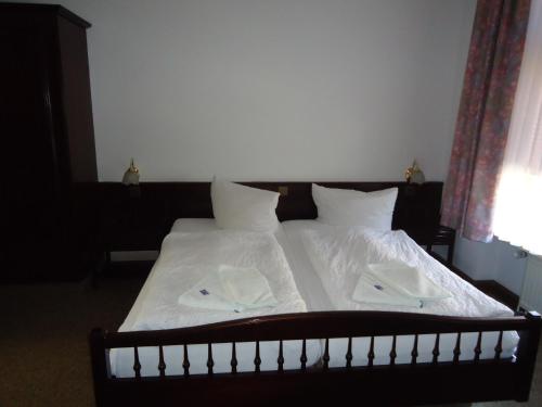 a bed with white sheets and white towels on it at Hotel Marthahaus in Halle an der Saale