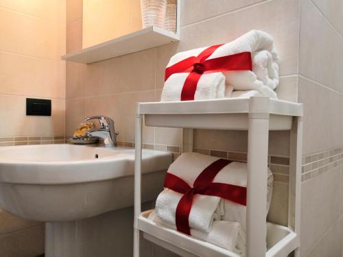 Baño con toallas en un estante junto a un fregadero en Appartamento Lungolago San Feliciano, en Magione