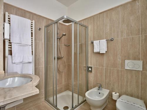 uma casa de banho com um chuveiro, um WC e um lavatório. em Hotel Bellavista em Menaggio