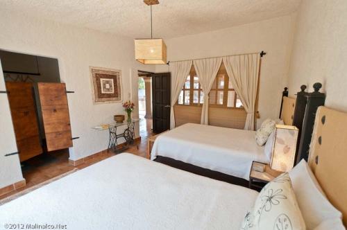 a large bedroom with two beds and a window at Hotel Boutique Casa de Campo Malinalco in Malinalco