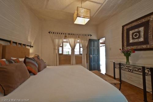 a bedroom with a large bed with a white bedspread at Hotel Boutique Casa de Campo Malinalco in Malinalco