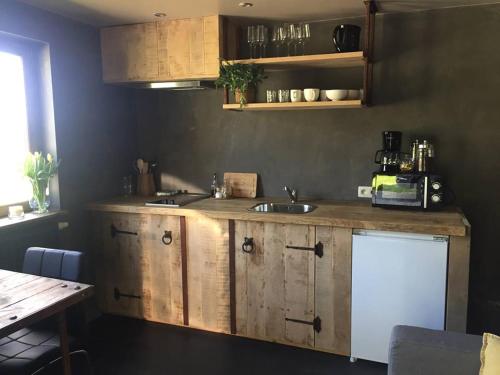 a kitchen with a wooden counter and a sink at Côté Campagne in Durbuy