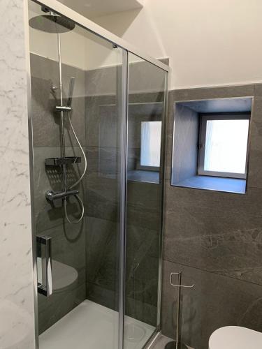 a shower with a glass door in a bathroom at Palazzo Elisei in Gubbio