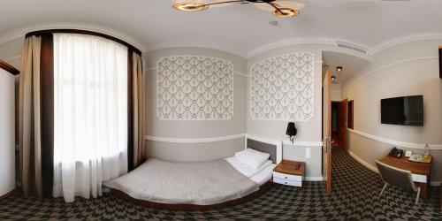 a bedroom with a bed and a window and a desk at Hotel Kamienica in Siedlce