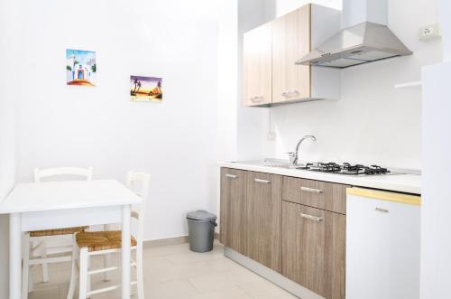 a kitchen with wooden cabinets and a white counter top at CASA Annmarie in Castellammare del Golfo