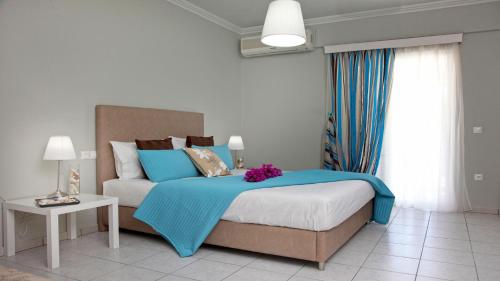 una camera da letto con un letto con una coperta blu di Nidri Bay Studios a Nydri