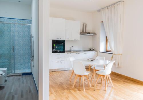 a kitchen and a dining room with a table and chairs at Atlantide holiday apartments in Castellammare di Stabia