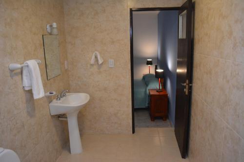 y baño con lavabo y espejo. en Hotel Isella en Salta