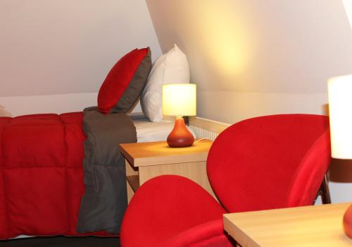 a living room with a couch and a red chair at Hotel Romano in Concepción