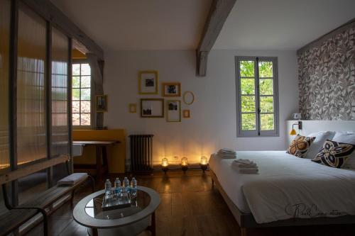 1 dormitorio con 1 cama grande y 1 mesa en Maison Doat 1823, en Perchède