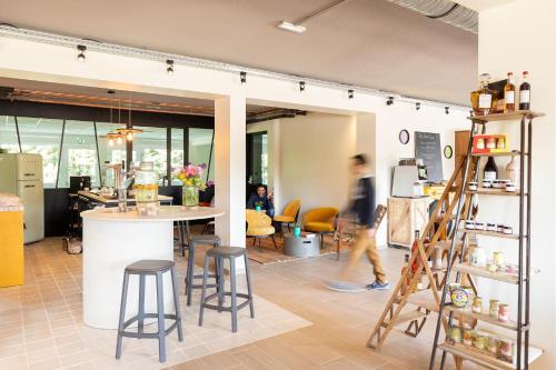 a person walking through a store with a ladder at greet Hotel Beaune in Beaune