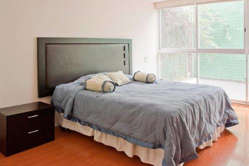 a bedroom with a large bed with a large window at Family Friendly 3 Rooms Apartment in Mexico City