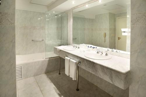 uma casa de banho com 2 lavatórios e um espelho grande em Parque Hotel Jean Clevers em Punta del Este
