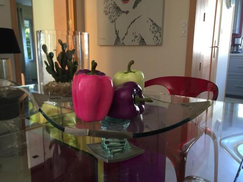 a glass table with two peppers on top of it at Le Gite d'Emilie in Entraygues-sur-Truyère