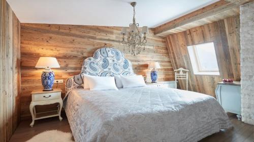 a bedroom with a bed and a wooden wall at HILLS POLYANA Hotel & SPA I ОТЕЛЬ ХИЛЛС ПОЛЯНА in Krasnaya Polyana
