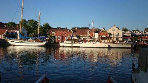 two boats are docked in the water next to houses at Garvaregården Hotel , B&B och Café in Askersund