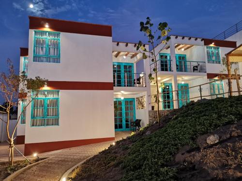 a white building on top of a hill at night at Hotel Villa Jazmin in Ica