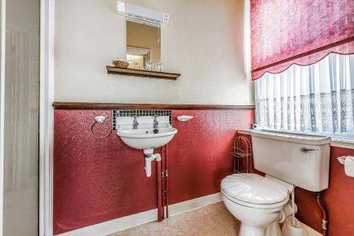 a bathroom with a toilet and a sink at Kenella House in Minehead