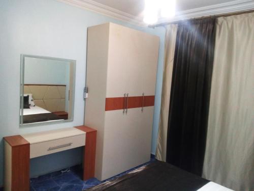 - une chambre avec un miroir et une commode avec un lit dans l'établissement Apartment at Milsa Nasr City, Building No. 22, au Caire