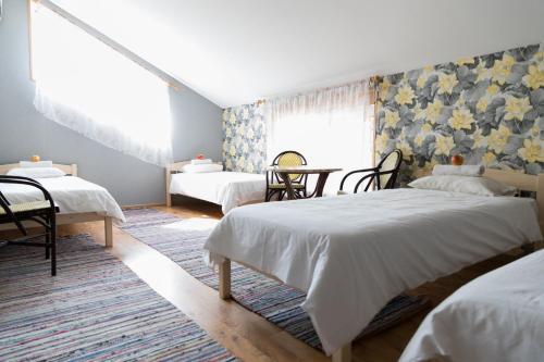 a bedroom with two beds and a table and chairs at Tindioru in Rõuge
