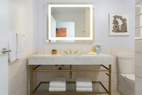 a bathroom with a sink and a mirror at 21c Museum Hotel Bentonville - MGallery in Bentonville