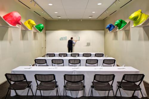 a man standing in a room with a table and chairs at 21c Museum Hotel Bentonville - MGallery in Bentonville