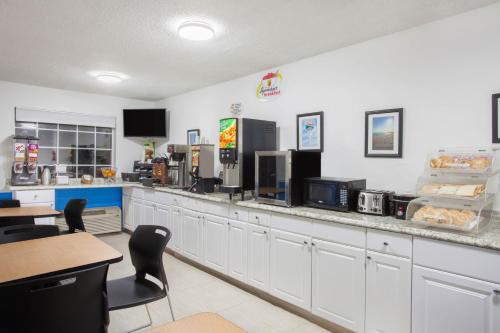 a fast food restaurant with a counter and chairs at Super 8 by Wyndham Pensacola in Pensacola