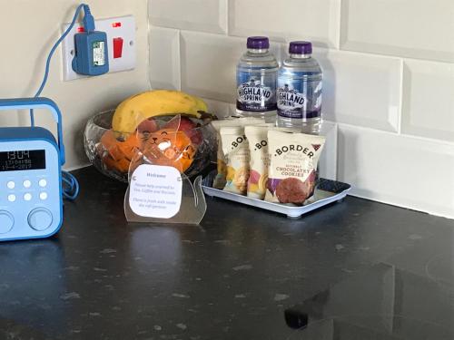 a counter with a bunch of food and bottles of water at Hillside View, Inverness in Inverness