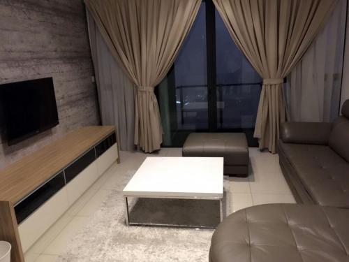 a living room with a couch and a table at ATLANTIS@MELAKA BY SWEETSTAY in Melaka