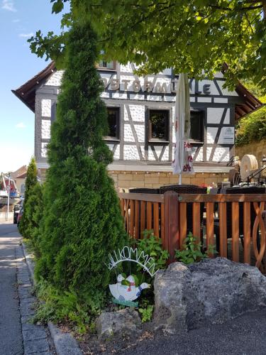 a house with a tree in front of it at Hotel Restaurant Klostermühle in Reutlingen