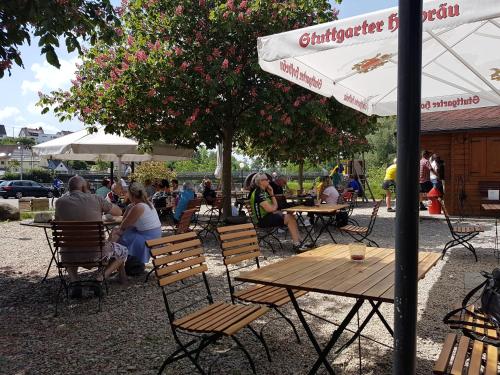 a group of people sitting at tables under an umbrella at Hotel Restaurant Klostermühle in Reutlingen