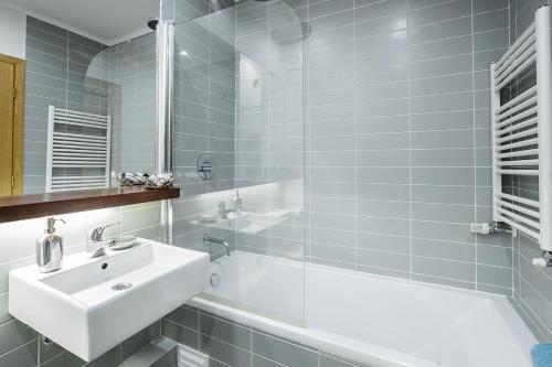 y baño con lavamanos, bañera y lavamanos. en LV Premier Apartments Baixa- PR, en Lisboa