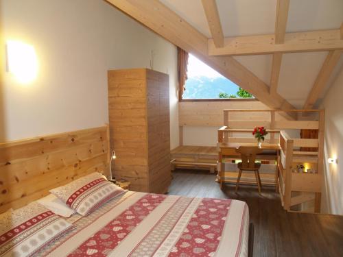 戴亞諾的住宿－Hotel Ganzaie，一间卧室配有一张床、一张书桌和一个窗户。
