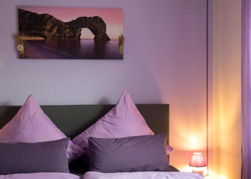a bedroom with a bed with purple pillows at Zimmervermietung Hebenstreit in Bernburg
