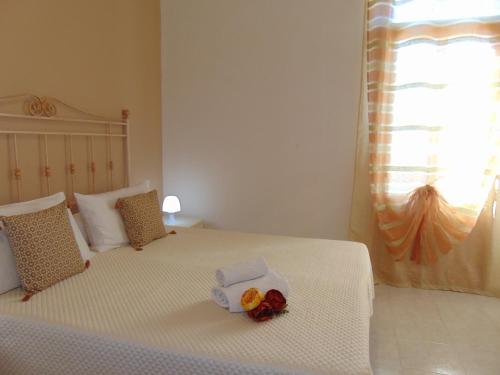 a bedroom with a white bed with flowers on it at Case Vacanza Donatella in San Vito lo Capo